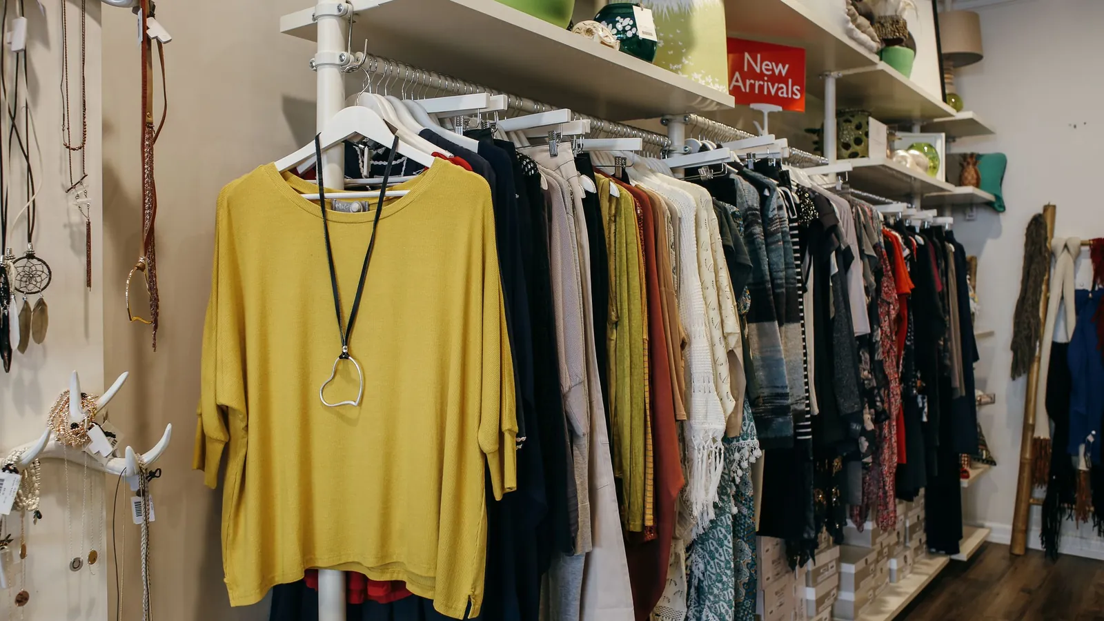 Apparel hanging on racks under a New Arrivals sign in a boutique